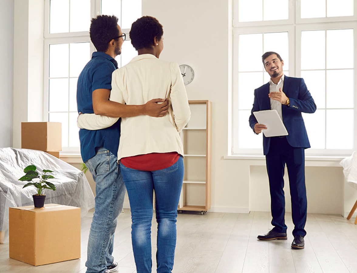 young couple speaking with a real estate agent